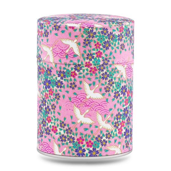 Boîte à thé artisanale Masuda 100 g, recouverte de papier washi rose orné de grues blanches et de petites fleurs violettes, couvercle assorti décoré.